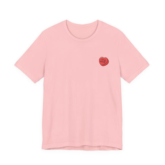 Pink t-shirt with a small red heart-shaped logo and 'ringette' text on a white background